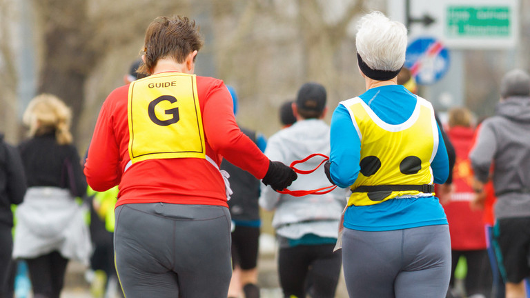 Taubblinde Person mit Assistenz treibt Sport