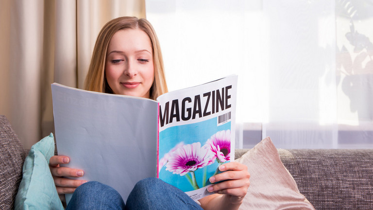 Frau mit einem Magazin-Heft in der Hand