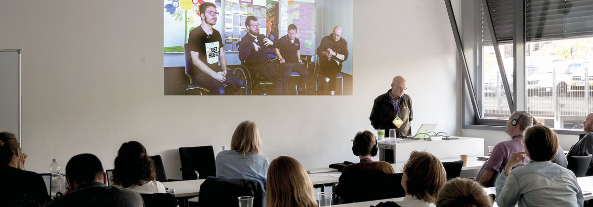 Blick in den Vortragsraum mit Albrecht Rohrmann und der Videovorführung