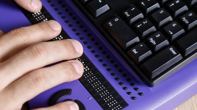 Brailletastatur mit einer Hand die liest.