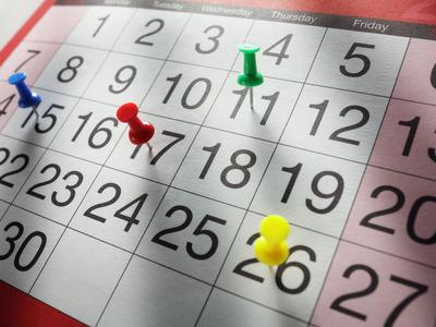 Kalenderblatt mit Pinnadeln auf verschiedenen Tagen