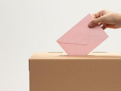 Mann wirft Stimmzettel in die Wahlurne