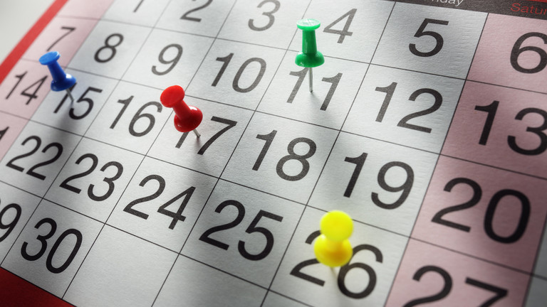 Kalenderblatt mit Pinnnadeln auf verschiedenen Tagen
