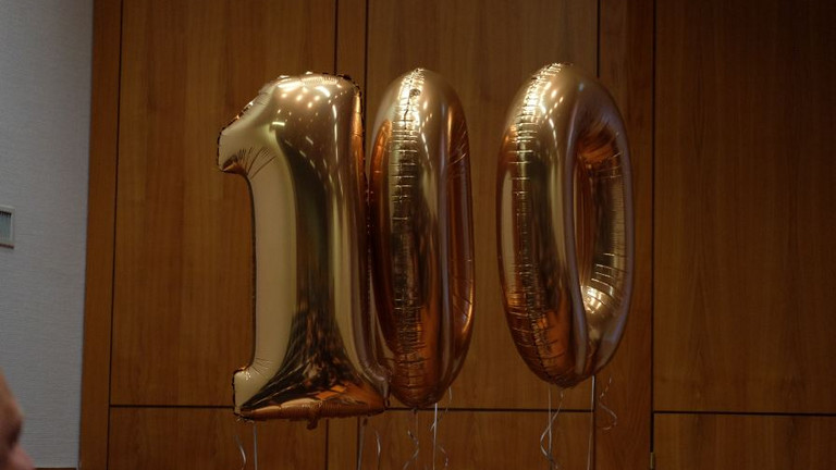 Die Zahlenballons 100 stehen für die Medaillen, die James Clarke für Marathons in 8 Jahren erreicht hatte. 