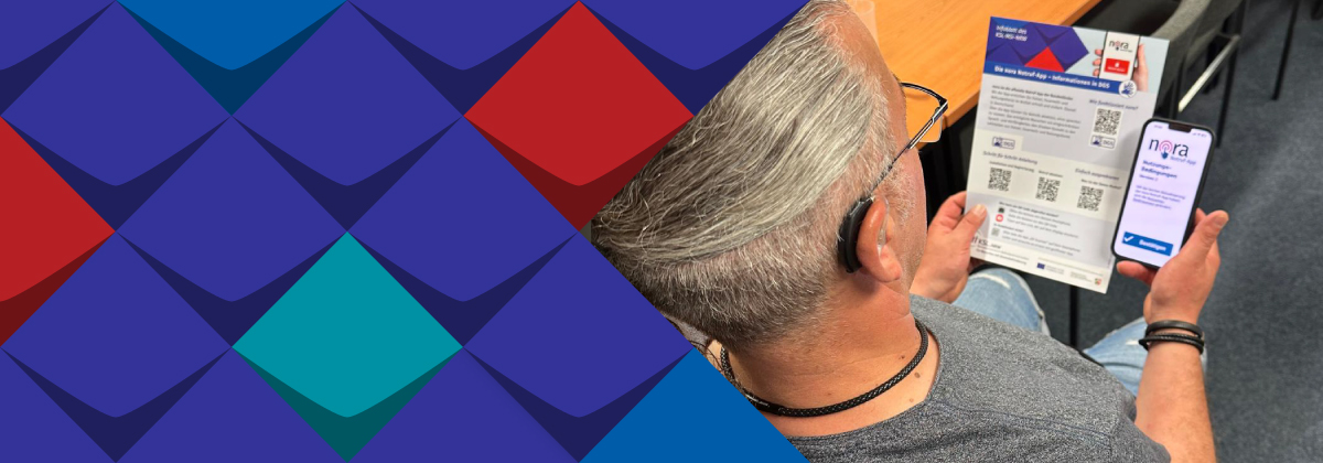 Ein Mann mit dem Hörgerät hat ein Smatphone mit dem Logo nora Notruf-App und liest ein Infoblatt zum Thema nora Notruf-App