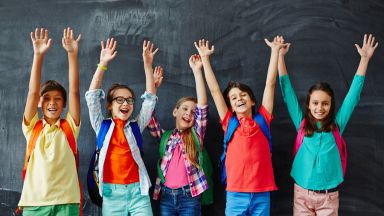 Kinder halten zustimmend die Hände hoch