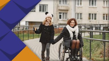 Frau im Rollstuhl geht/fährt mit ihrer Tochter spazieren