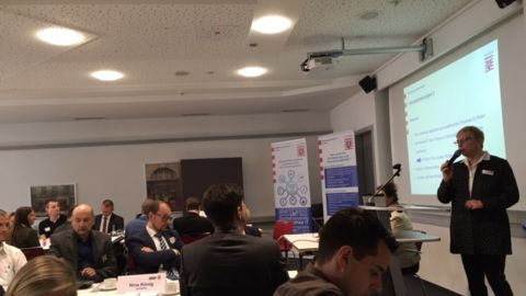 Prof. Dr. Erdmuthe Meyer zu Bexten steht vorne am Mikrofon und spricht zu vielen Personen die vor Ihr sitzen.