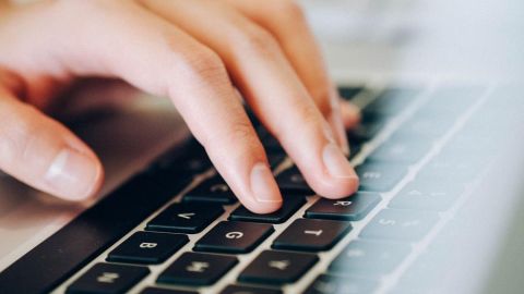 Online-Veranstaltung. Die Hand tippt auf Computertastatur.