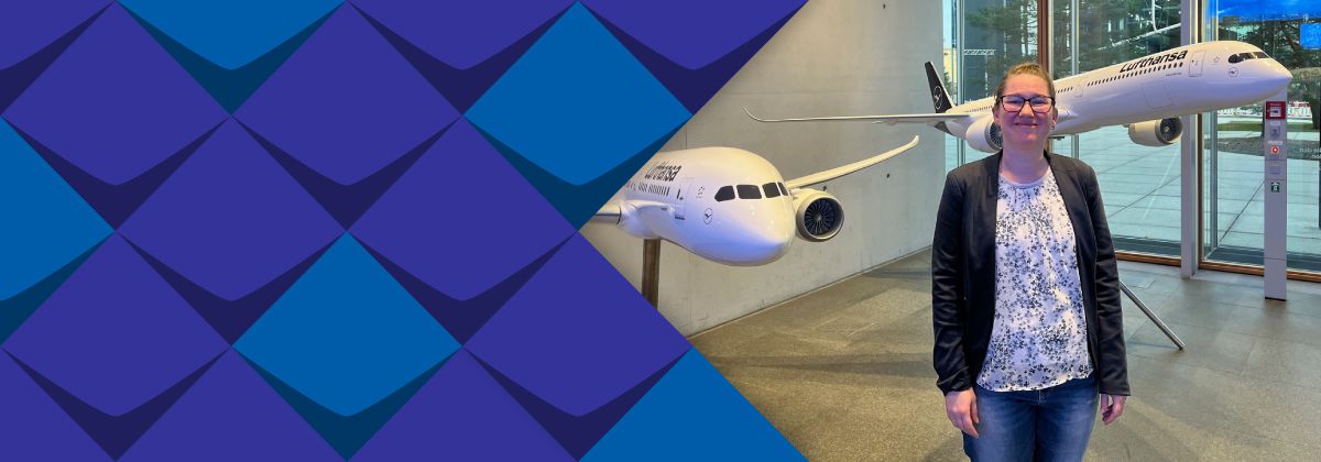 Melanie Wegerhoff  steht vor zwei großen Lufthansa-Flugzeugmodellen.