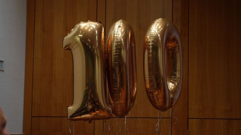 Die Zahlenballons 100 stehen für die Medaillen, die der Referent James Clarke für Marathons in 8 Jahren erreicht hatte.