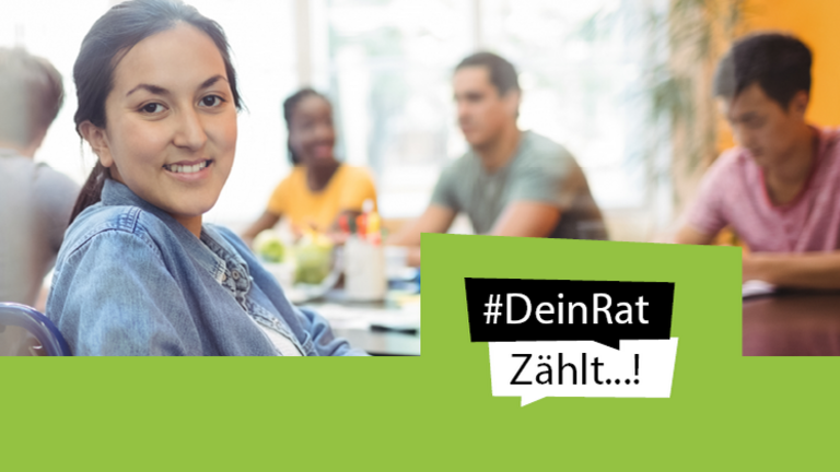 Eine Person schaut aus einer Gruppe von der Arbeit auf.